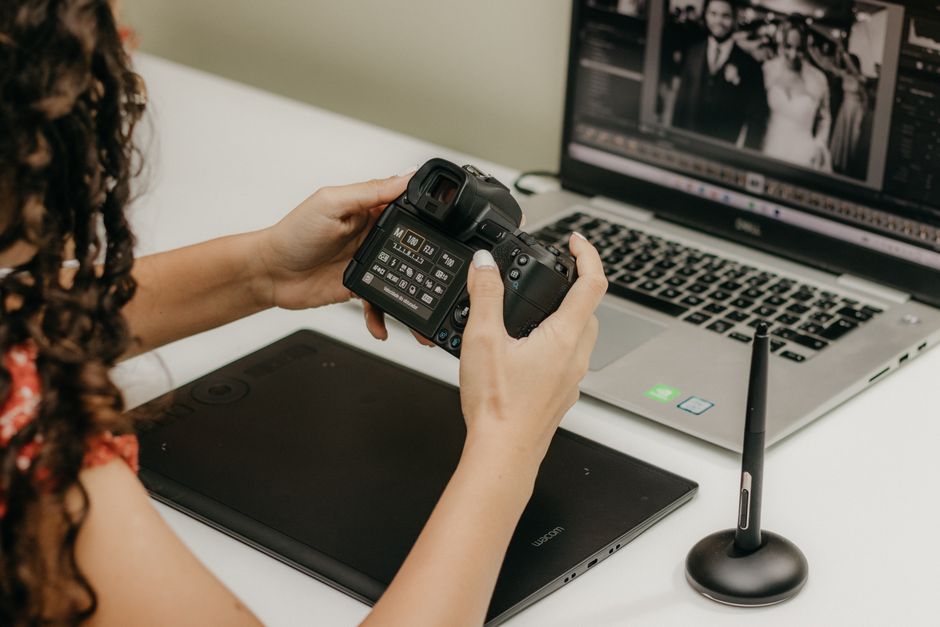 Professional wedding photographer adjusting camera settings at a venue